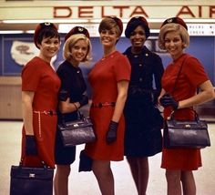 four women in red and blue uniforms are posing for the camera with their luggage bags