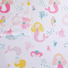 a white sheet with pink and blue mermaids on it, along with other sea animals