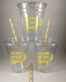 four plastic cups with yellow and white striped straws in the bottom one is empty