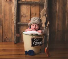 a baby in a bucket with a sign that says gone fishin'on it