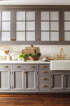 a kitchen with gray cabinets and wooden floors