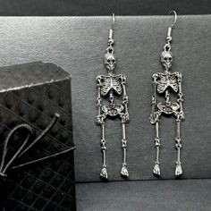 Get ready to dance the night away with these one-sided skeleton earrings in a vintage metallic silver finish! Perfect for any occasion - Halloween, Day of the Dead, a birthday party, or a night out with friends. Lightweight, articulated (all limbs are movable) and beautifully detailed, these earrings make a unique and original gift for yourself or someone special. Add some gothic, punk, and tattoo fashion to your look with these playful and quirky CALACAMANIA™ accessories Earrings details: Size: Edgy Skull Earrings For Parties, Gothic Skull Earrings For Halloween, Punk Skull Earrings For Party, Edgy Halloween Jewelry For Costume Party, Metal Halloween Party Jewelry, Gothic Skull Metal Earrings, Gothic Skull Earrings For Party, Halloween Punk Style Single Earring, Gothic Single Earring For Party