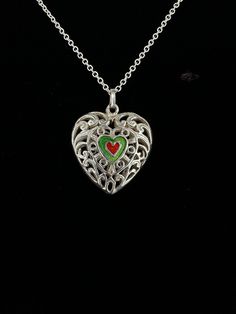 Vintage Sterling Silver Filigree Open Cage Heart Enamel Pendant Necklace 18"  Item here is a vintage sterling silver filigree open cage heart enamel pendant necklace. This pendant is unmarked but tests for sterling silver. Necklace closes with a spring ring. Neat filigree design and pretty enamel hearts in the center. Condition: Good; item is pre-owned and may have some signs of light use and age related wear. Please look closely at the pictures provided as they are an extension of our written description. Measurements: Length: 16 in Chain Width: 2mm Pendant: 1 in x 1 in Weight: 7.8g 8669F Vintage Enamel Heart Necklaces, Vintage Heart Enamel Necklaces, Vintage Enamel Heart Necklace, Vintage Heart Enamel Necklace, Silver Heart-shaped Enamel Jewelry, Heart-shaped Silver Enamel Jewelry, Silver Enamel Heart Pendant Necklace, Ornate Necklace For Valentine's Day Gift, Silver Enamel Locket Necklace