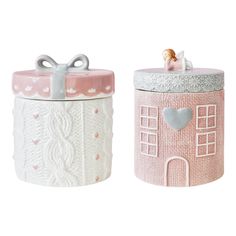 two ceramic containers with designs on them, one is pink and the other is white