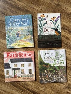 three children's books sitting on top of a wooden table