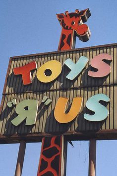 a large sign that says toysrus with a giraffe on top