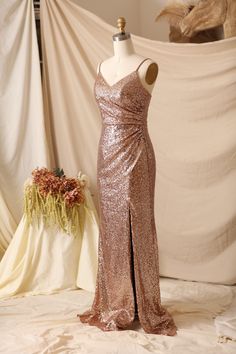 a dress on a mannequin in front of a white backdrop with flowers and fabric