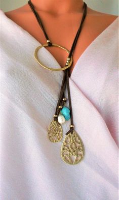 Lovely Leather Lariat necklace. Genuine Turquoises tassel, Unique design NEW vacation Jewelry purchase, never used This is a stunning statement necklace Components include: shiny gold tone quality Brass Genuine 31 inch flat Leather 6 inch Leather Tassel with stone and Brass dangles Handmade in Asia Ready to ship NO waiting Only ONE necklace available Thank you so much for visiting :kaysclassyboutique@etsy.com Bohemian Lariat Necklace With Tassels, Handmade Lariat Tassel Necklace, Bohemian Lariat Necklace With Tassels For Gifts, Bohemian Lariat Necklace With Tassels As Gift, Adjustable Metal Tassel Necklace As Gift, Tassel Long Necklace Jewelry For Gifts, Long Tassel Necklace As Gift, Long Tassel Necklace Jewelry For Gift, Long Tassel Necklace For Gifts