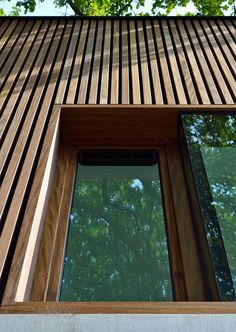 an image of the outside of a house with wood sidings and glass window frames