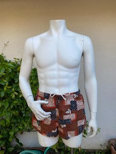 Vintage men's swim trunks in a great brown, orange and black print.  Small front pocket.  Elastic and drawstring waist.  Fabric feels like cotton barkcloth.  Great vintage condition.  Front right leg has what looks like a water mark and 3 tiny holes. label:  Catalina; Styled for the Stars of Hollywood fabric:  feels like cotton barkcloth size:  labeled size is 36.  Modern size is smaller.  Please check measurements for an accurate fit.  Questions are welcome! trunks were measured across the front side lying flat waist 14 1/2" - 17" rise 12 1/2" outer length 11 1/2" inseam 2" Brown Cotton Shorts For Summer, Short Cotton Swim Trunks For Beach Season, Cotton Short Swim Trunks For Beach Season, Brown Cotton Drawstring Shorts, Cotton Drawstring Swim Trunks, Cotton Swim Trunks For Poolside, Fitted Swim Trunks With Drawstring For Summer, Relaxed Fit Cotton Swim Trunks For Beach Season, Cotton Swim Trunks With Drawstring For Summer