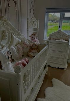 a white baby crib with teddy bears in it and a window to the outside