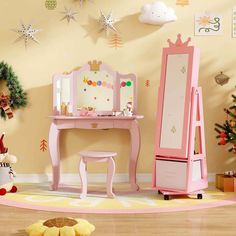 a child's dressing table and mirror in a room with christmas decorations on the wall