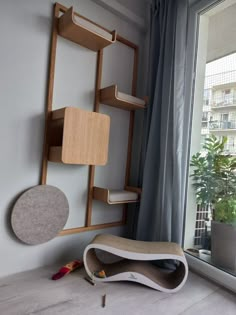 a room with a window, bookshelf and various objects on the floor next to it