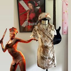 two mannequins dressed in costumes with guitars and posters on the wall behind them