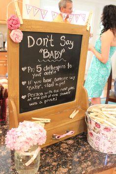 a baby shower sign on the counter in front of a blackboard with words don't so baby written on it