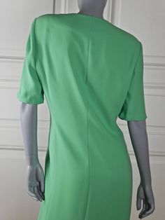 This German vintage green dress has a V neckline, and closes in the front with eight black and gold buttons. Three more of these buttons are decorative and are positioned on the right side of the V neckline, with three imitation black buttonholes on the left side of the V neckline. This stunning slimline knee-length dress has two imitation flap hip pockets. The summer dress has padded shoulders and short sleeves. The high-quality dress is fully lined in green 100% acetate material. Brand label: Green Rayon Knee-length Dress, Green Knee-length Buttoned Shirt Dress, Green Viscose Knee-length Dress, Vintage Knee-length Dress With Button Closure, Green Knee-length Shirt Dress With Button Closure, Vintage Green Dress, Country Dresses, High Quality Dress, Sleeveless Dress Summer