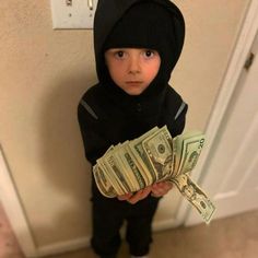 a young boy in a black hoodie holding money