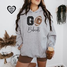 Do you need the perfect gift for that football mama?  Personalize this super cozy hoodie for game day.  Show your school spirit with your custom logo on the front with the child/players number on the football.  The design features a distressed/vintage faded feel. **If you would like a hoodie color that is not offered, send me a message and we will let you know if it's available. These Hoodies are made of high-quality cotton & polyester.  Thank you for browsing our shop, we hope you find somethin Team-colored Hoodie For Game Day In Fall, Varsity Hoodie For Game Day In Fall, Fall Team Name Hoodie Fan Gear, School Spirit Team-colored Hoodie For Game Day, Fall Fan Gear Hoodie With Team Name, Team Spirit Hoodie For Game Day In Fall, Team Spirit Hoodie For Game Day, School Spirit Hoodie With Team Name For Fan Gear, School Spirit Hoodie For Fall