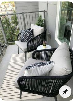 two black wicker chairs sitting on top of a balcony