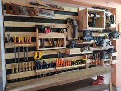 a workbench filled with lots of tools and pliers hanging on the wall