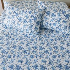 a blue and white floral bed spread with matching pillow cases