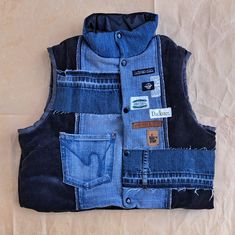 a vest made out of old jeans with patches on the front and back pockets