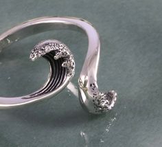 This sterling silver wave ring is simple, yet, intricate at the same time as two opposing waves come crashing towards each other. The waves are beautifully detailed and textural, illustrating the graceful flow of the ocean and the movement of the waves. Truly a ring for anyone who loves nature, especially the majestic essence of water. As pictured, this ring is a size 7 and adjustable. Adjustable Silver Wavy Rings, Adjustable Sterling Silver Wavy Rings, Waves Jewelry, Wax Carving Jewelry, Sea Rings, Ocean Ring, Surfer Jewelry, Wave Jewelry, Jewelry Ocean