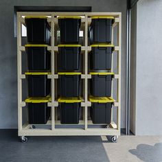 several black and yellow bins are stacked on top of each other in a storage unit