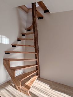 a wooden spiral staircase in an empty room