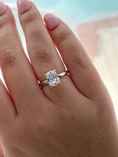 a woman's hand with a diamond ring on it