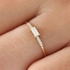 a woman's hand with a diamond ring on it