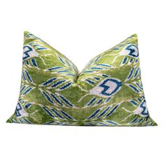 a green pillow with blue and white designs on the front, sitting on a white background