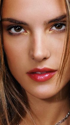 a close up of a woman with long hair and red lipstick on her face, wearing a necklace