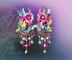 "This Beautiful Pair of Rose earrings is exquisitely feminine with it's Hand-Painted bouquets of Roses and Tulips.  Each piece is hand-collaged onto intricate brass filigrees and adorned with Swarovski rhinestones for an added sparkle!  Vintage Rose, Mint Green and Pearl glass beads dangle from the 'gardens' like drops of delicate, colorful rain. :) The butterflies flutter amongst the flowers adding a touch of whimsy. Available with French Wires, Posts or Clip-Ons. -4 1/4\" Long x 1 1/2\" Wide -0.6 oz. ea *Comes Ready To Gift in Decorative Packaging *Each Pair is Made Just for You!  Kerala Rose Pinterest page: https://www.pinterest.com/keralarose3/pins/ To re-enter my shop, Kerala Rose:  https://www.etsy.com/shop/kerala" Bead Curtains, Silver Payal, Floral Art Nouveau, Shabby Chic Jewelry, Filigree Jewelry, Beaded Tassel Earrings, Painted Jewelry, Long Tassel Earrings, Hand Painted Jewelry