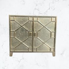 a metal cabinet with geometric designs on the front and bottom, sitting on a marble surface