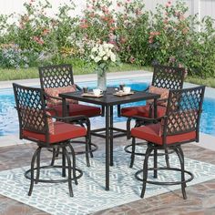 an outdoor dining set with red cushions and barstools next to a swimming pool