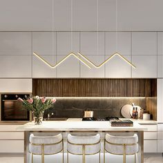 a kitchen with marble counter tops and white chairs next to an island topped with flowers