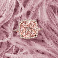 an engagement ring with pink and white diamonds in the center, surrounded by fluffy pink feathers