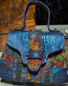 Coming soon! Message me if you're interested! This one of a kind listing is handmade in my home in the beautiful desert southwest of the United States. The stunning blue crocodile embossed leather of this highly structured bag beautifully coordinates with the multi-color floral goat skin used on the main body. The blue waterproof canvas interior has a center compartment, a zipper pocket and a slip pocket. The bag has a leather top handle and a flap closure. Bag dimensions: -7.5 inches tall -10 inches wide -3.5 inches deep Disclaimer: Items are hand made and have slight variations and natural flaws Structured Handbags, Beautiful Desert, Desert Southwest, Structured Bag, Southwest Desert, Clutch Handbag, Leather Top, Embossed Leather, My Home