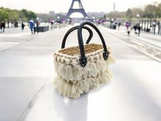 This handmade straw Bag is the ultimate accessory for various occasions, such as bachelorette parties, weddings, and honeymoons. It is also perfect for multiple uses, such as shopping, beach outings, or even corporate meetings. This durable bag features sturdy leather handles and white tassels all around.  Height without the handle: 7 inches | 12 1/2 inches with the handle Length:  10 inches Width: 6 inches Straw Beach Bag, Bridesmaid Bags, Straw Basket, White Tassel, Round Rock, Honeymoons, Bachelorette Parties, Leather Handles, Bridesmaid Gift