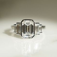 an emerald cut diamond ring with three baguets