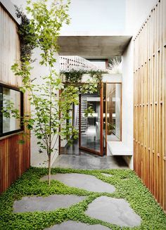 the walkway is lined with green grass and stone stepping stones that lead to an entrance