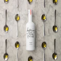 a bottle of olive oil surrounded by spoons