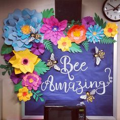 a bulletin board with flowers and bees on it that says be amazing next to a microwave