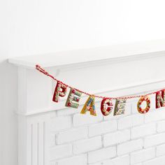 a white brick fireplace with a red ribbon that says peace on it