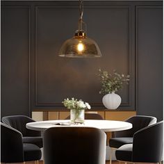 a dining room table with chairs and a vase filled with flowers on the table next to it