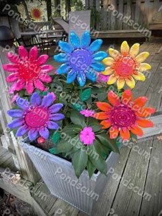 colorful flowers in a wooden container on a deck