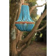 a blue beaded chandelier hanging from a tree