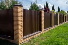 a brick fence in front of some green grass