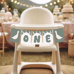 a baby's first birthday party with a high chair and one banner on it